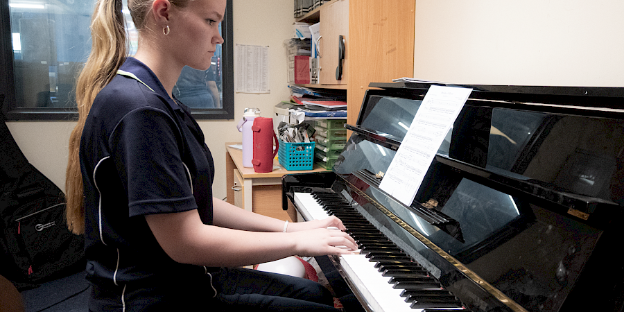 Student playing the piano in an Instrumental Music lesson