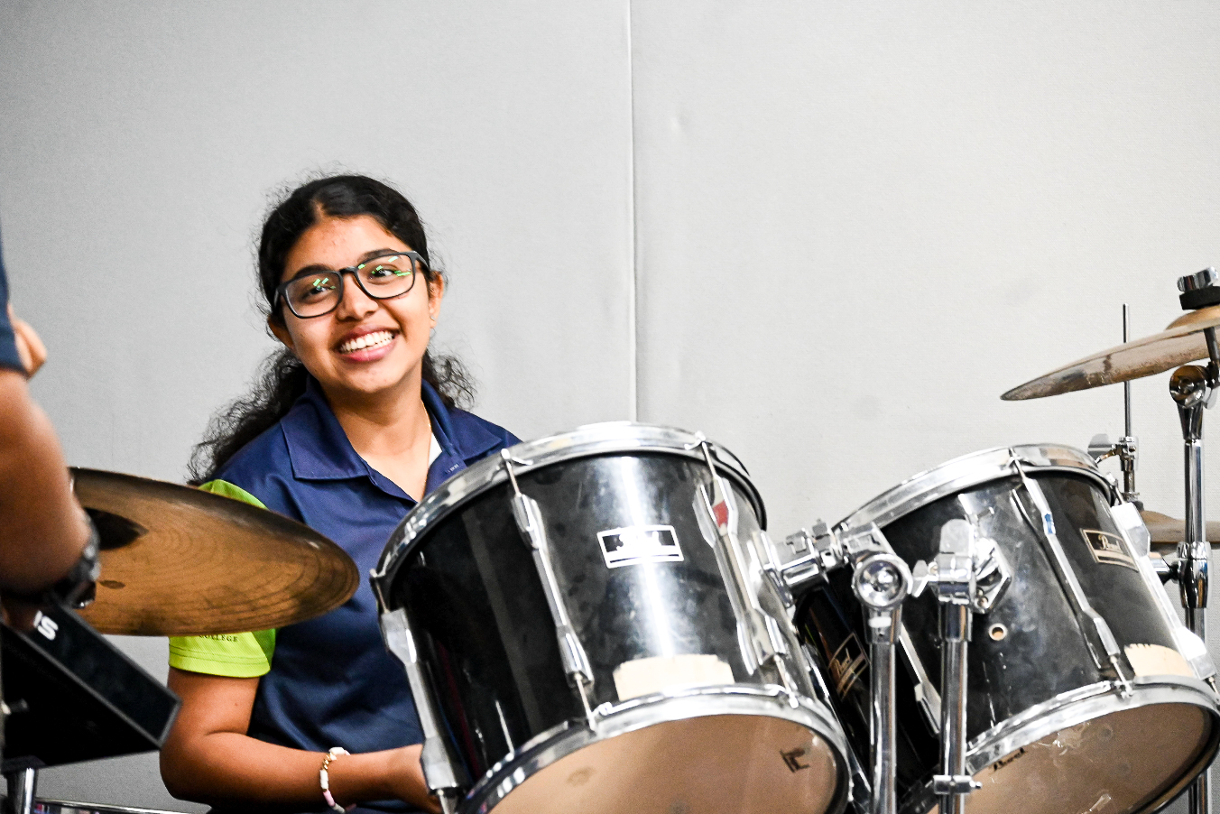 Student playing the drum kit in an Instrumental Music lesson