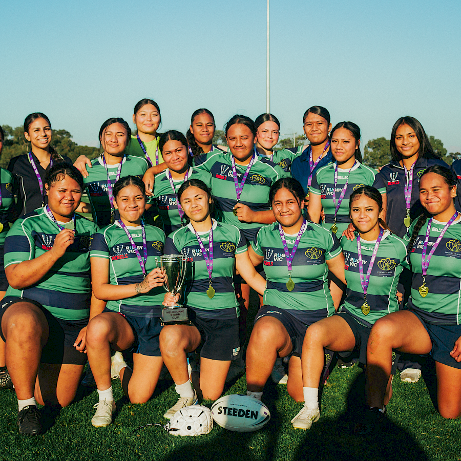 Fountain Gate Secondary College girls' rugby team posing together on the field with medals